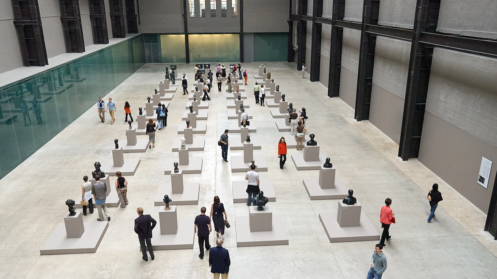 Menschen im Modern Art Museum in London vor Skulpturen in einer klaren, ruhigen Architektur.