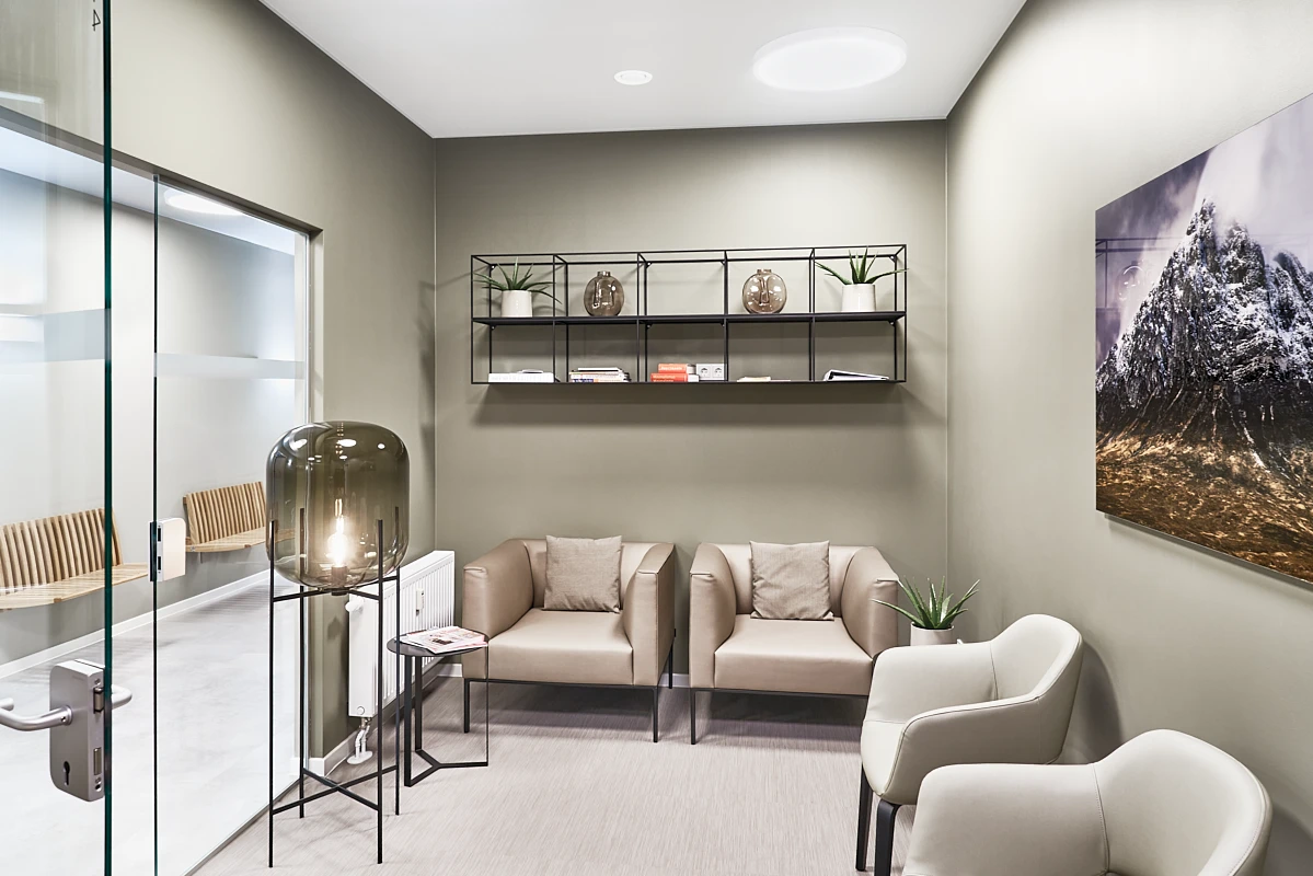 Stilvolle Patientenlounge der RKM 740 Facharztklinik in Düsseldorf mit Sitzbereich, Glaswand und ruhiger hochwertiger Atmosphäre