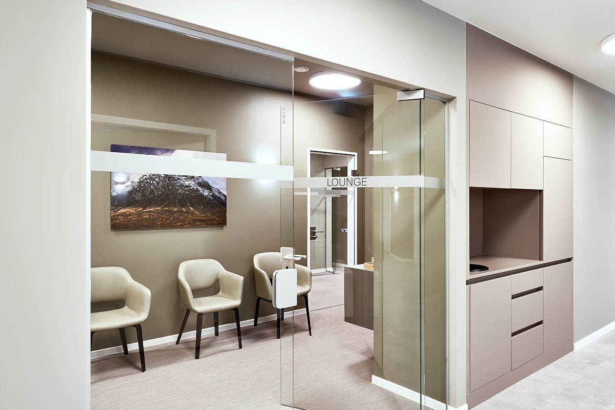 Gläserner Eingang zur Patientenlounge der RKM 740 Facharztklinik in Düsseldorf mit Sitzbereich und hochwertiger Innenarchitektur